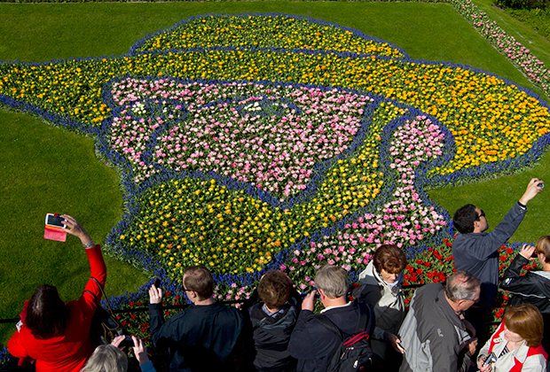 Туристы фотографируются на фоне цветочной композиции, изображающей художника Винсента Ван Гога. Кёкенхоф, Нидерланды, апрель 2015 года